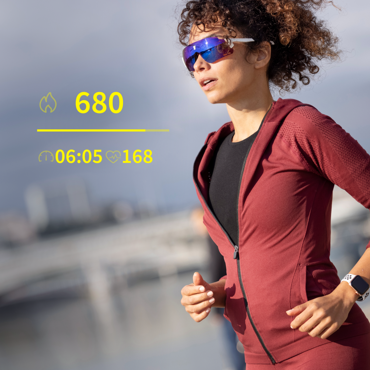 Một phụ nữ đeo kính thể thao ENGO và Apple Watch đang chạy, phía trước hiển thị mô phỏng trường dữ liệu xuất hiện trong tròng kính.